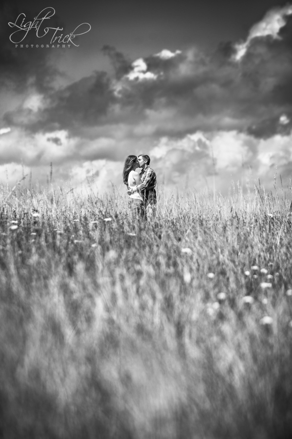 couple in a field with clouds in the background